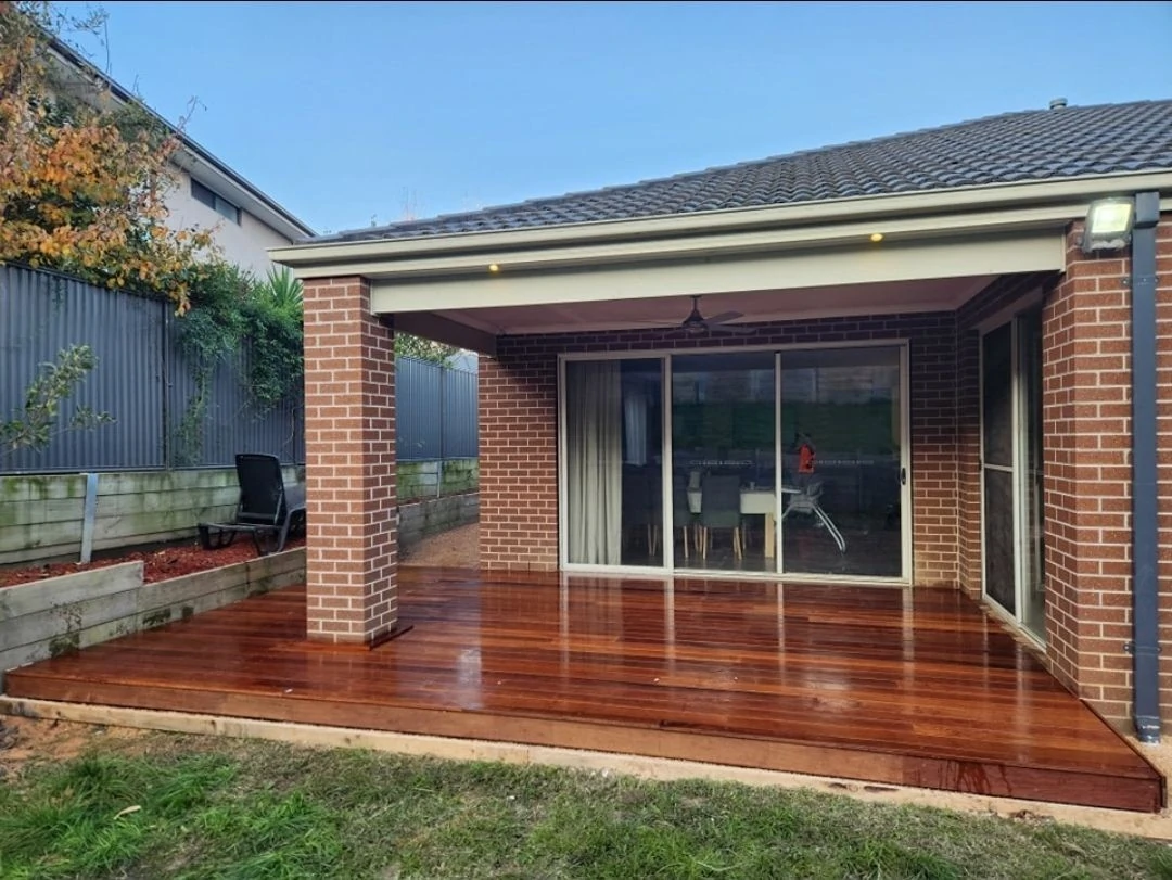 Timber deck alongside a brick home